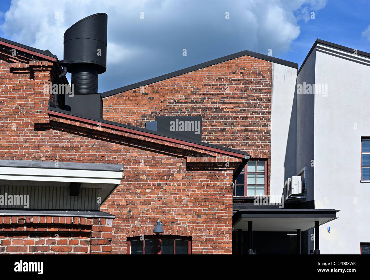 Modernes Ziegelstein- und Betongebäude mit schwarzem Entlüftungsrohr Stockfoto