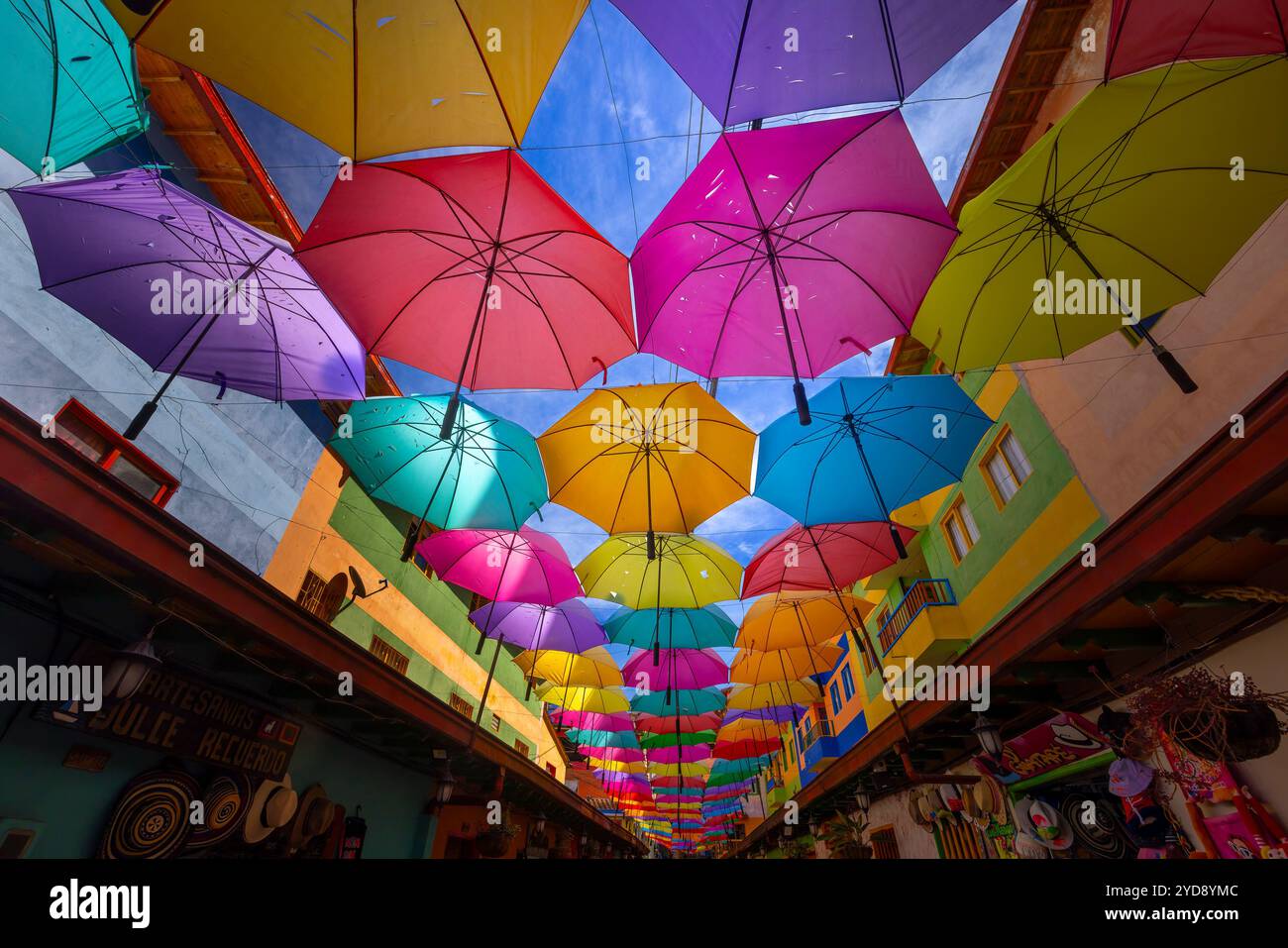 Eine der farbenfrohen Straßen in der Kolonialstadt Guatape in Kolumbien, mit farbenfrohen Regenschirmen Stockfoto