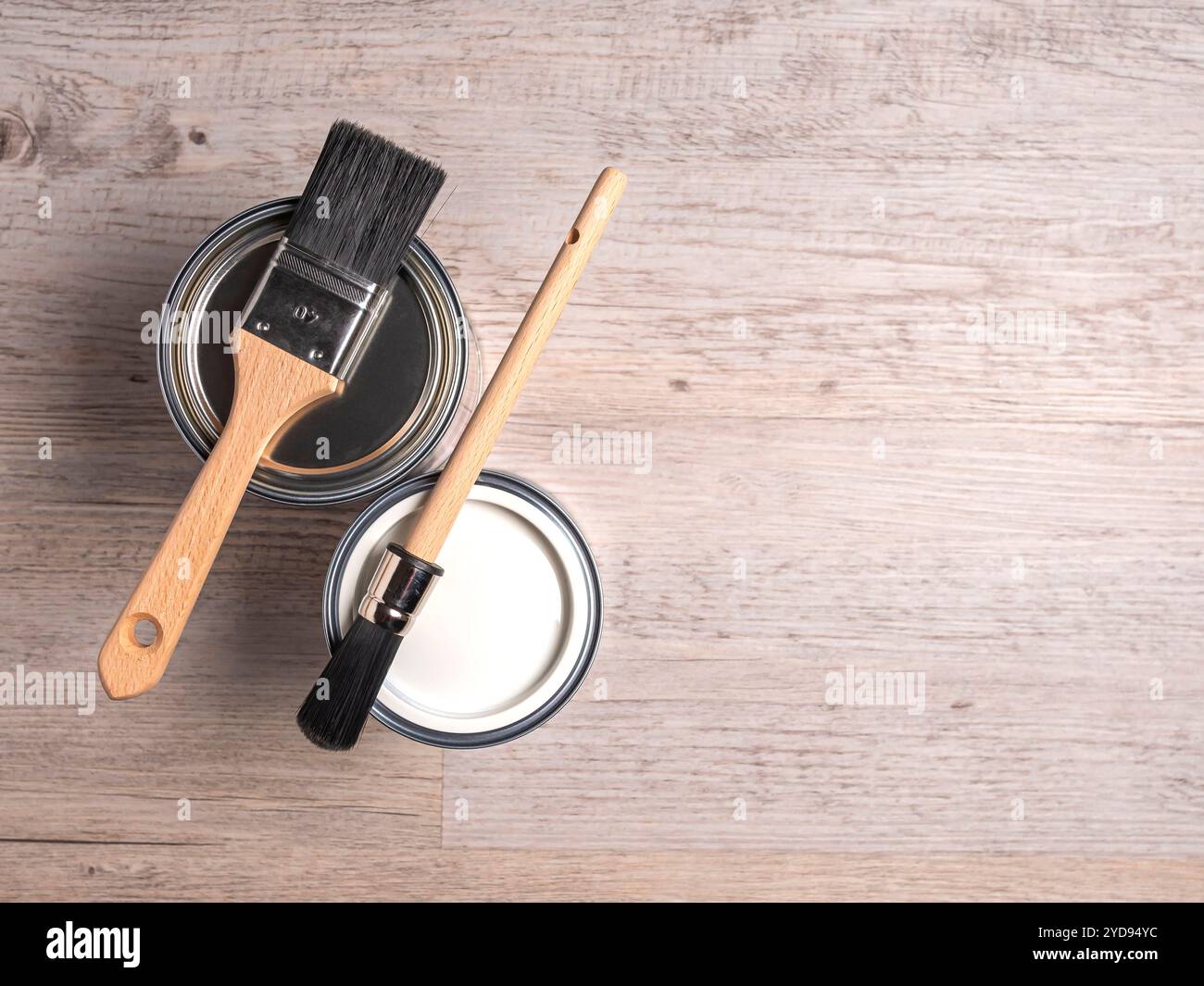 Zwei Farbdosen mit sauberen Pinseln, Draufsicht, Holzhintergrund, Kopierraum. Stockfoto
