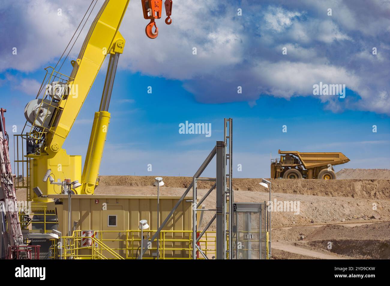 Ein Kran am Brecher in einem Kupferbergwerk in Chile, mit einem großen Müllwagen, der im Hintergrund vorbeifährt. Stockfoto