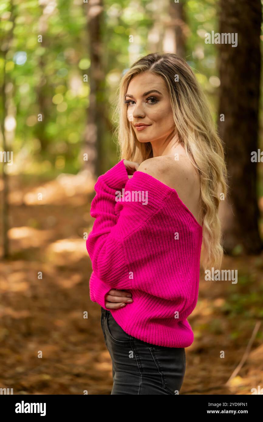 Ein schönes blondes Modell posiert im Freien, während es das Herbstwetter genießt Stockfoto