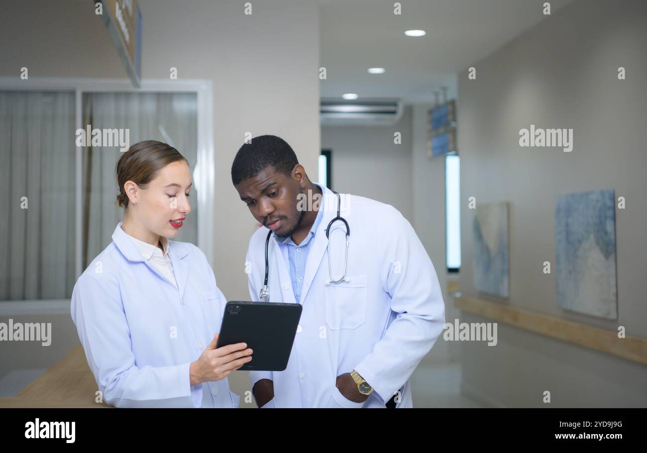 Beide Ärzte analysieren die MRT-Ergebnisse des Patienten auf einem Tablet, um Ideen auszutauschen und neue Informationen für den Patienten zu finden Stockfoto