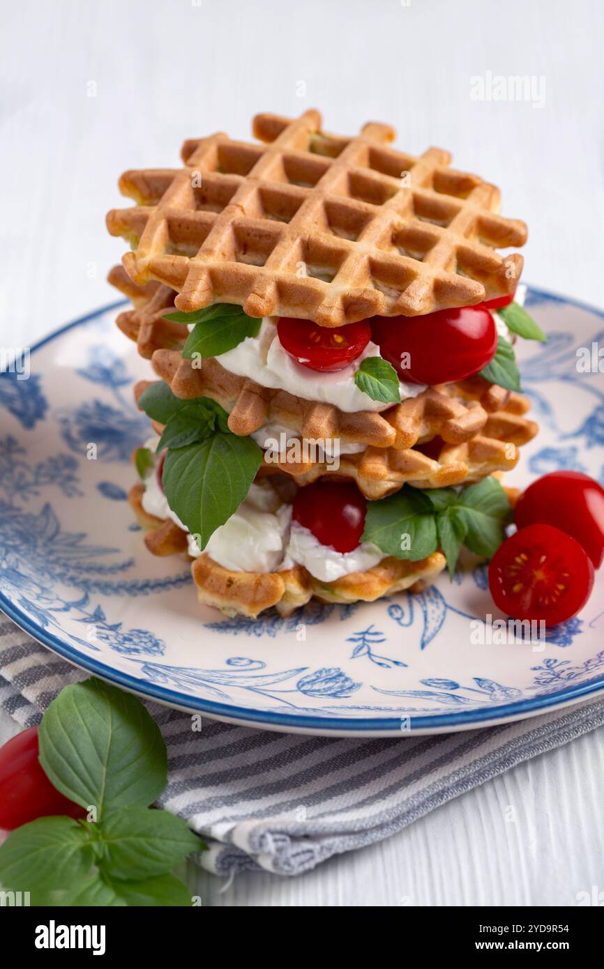 Zucchini-Waffeln mit Frischkäse und Kirschtomaten. Stockfoto