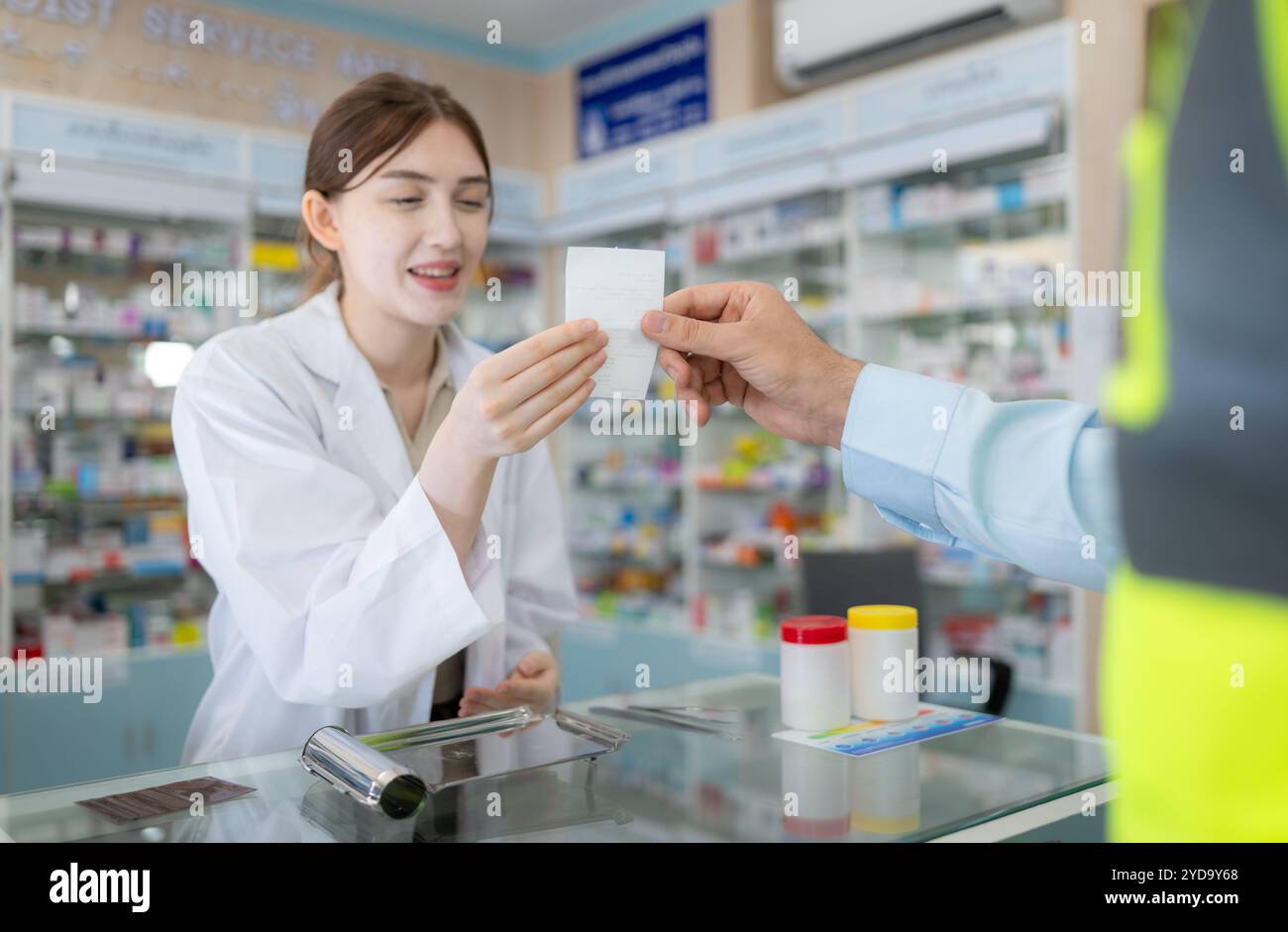 Ingenieure bringen Rezepte in die Apotheke, um dem Apotheker zu zeigen, wann er Medikamente kauft Stockfoto