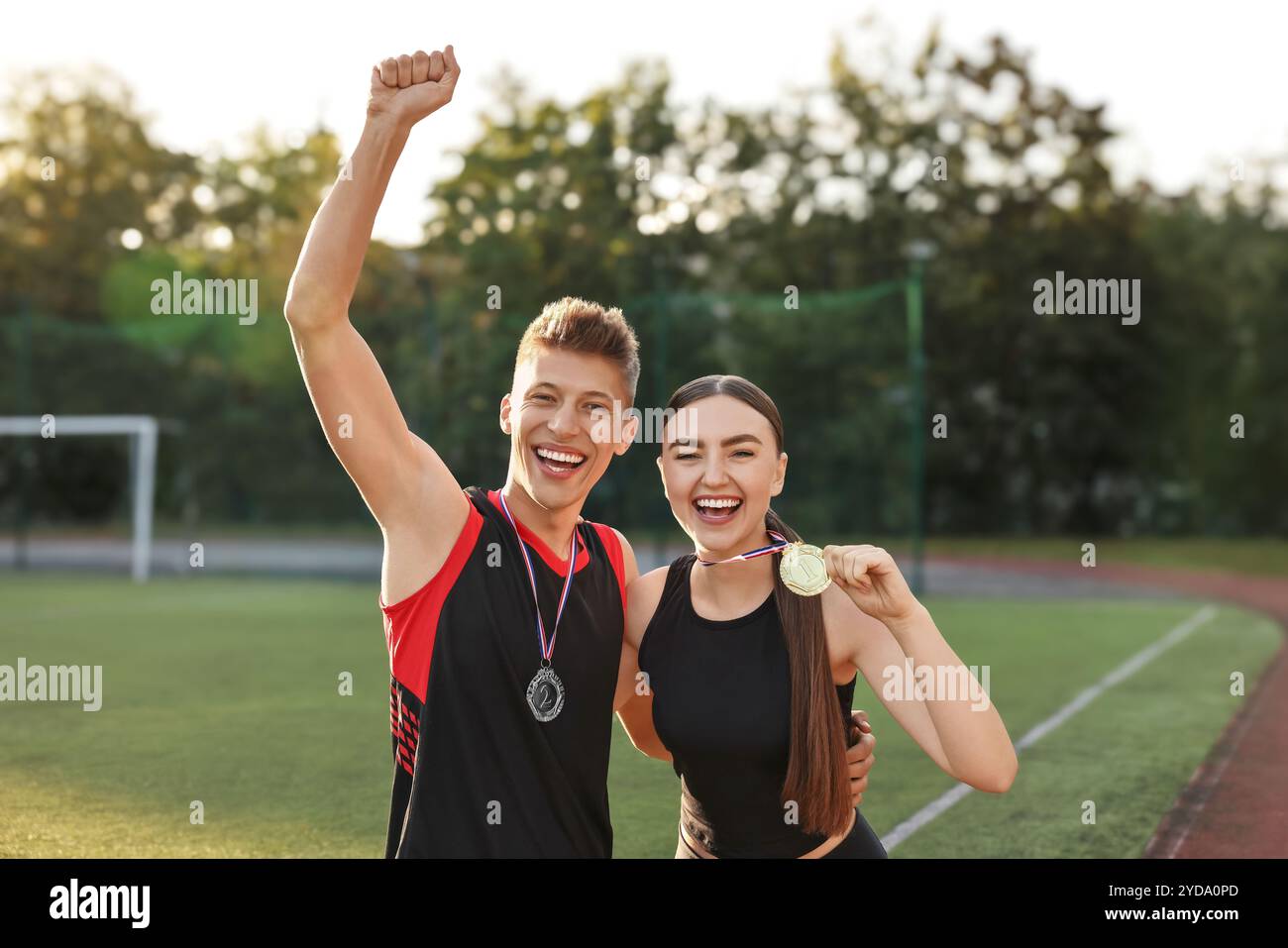 Porträt glücklicher Gewinner mit Medaillen im Stadion Stockfoto