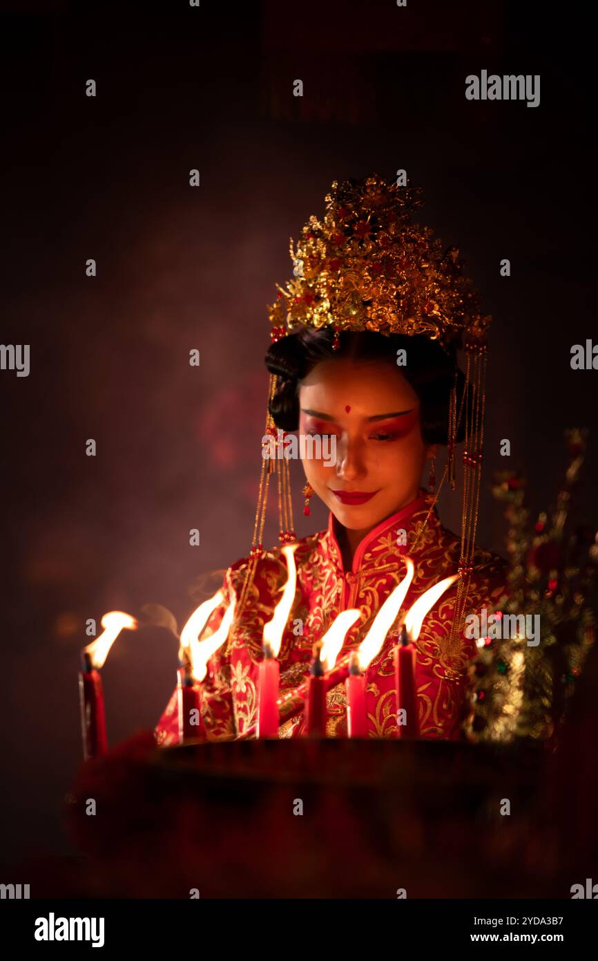 Chinesin wünscht, betet und zündet Kerzen an. Anlässlich des jährlichen chinesischen Neujahrsfestes in einem verehrten Schrein Stockfoto