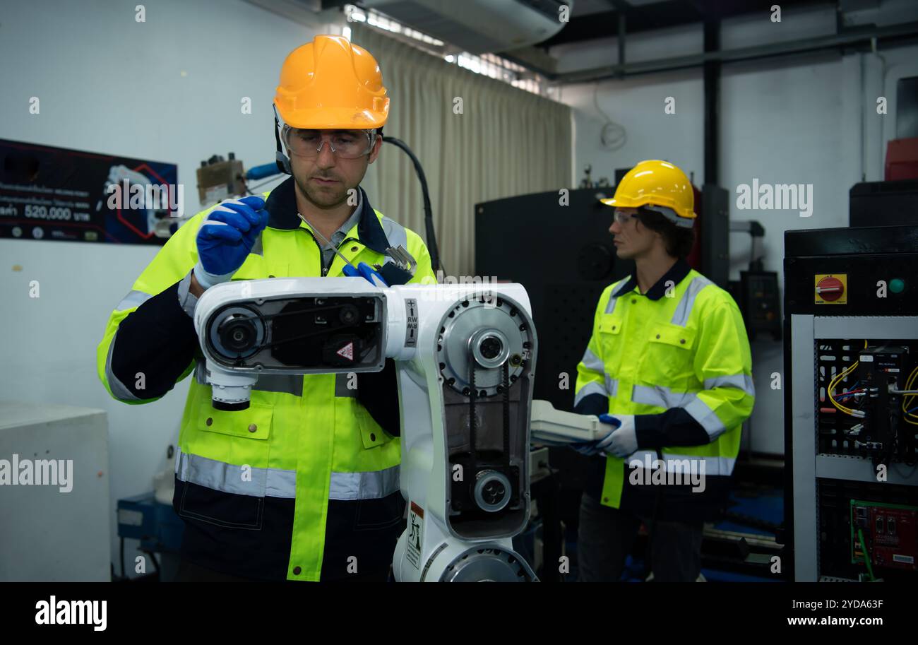 Ein großer Schweißroboter wird von einem Roboteringenieur inspiziert und gesteuert. Nachdem die Maschine für die angegebene verwendet wurde Stockfoto