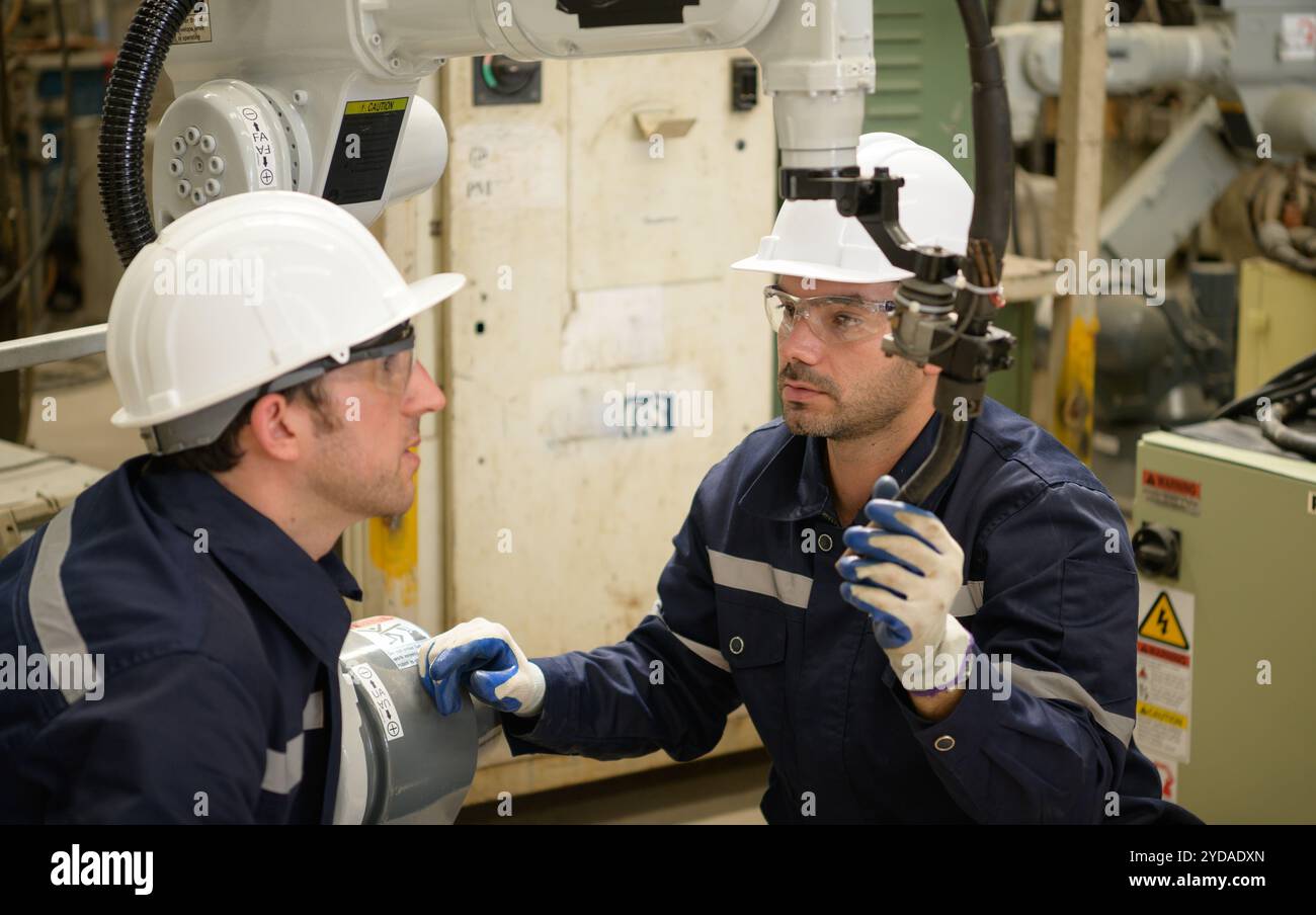 Die beiden Ingenieure prüfen die Funktion von Schweißrobotern. Stockfoto