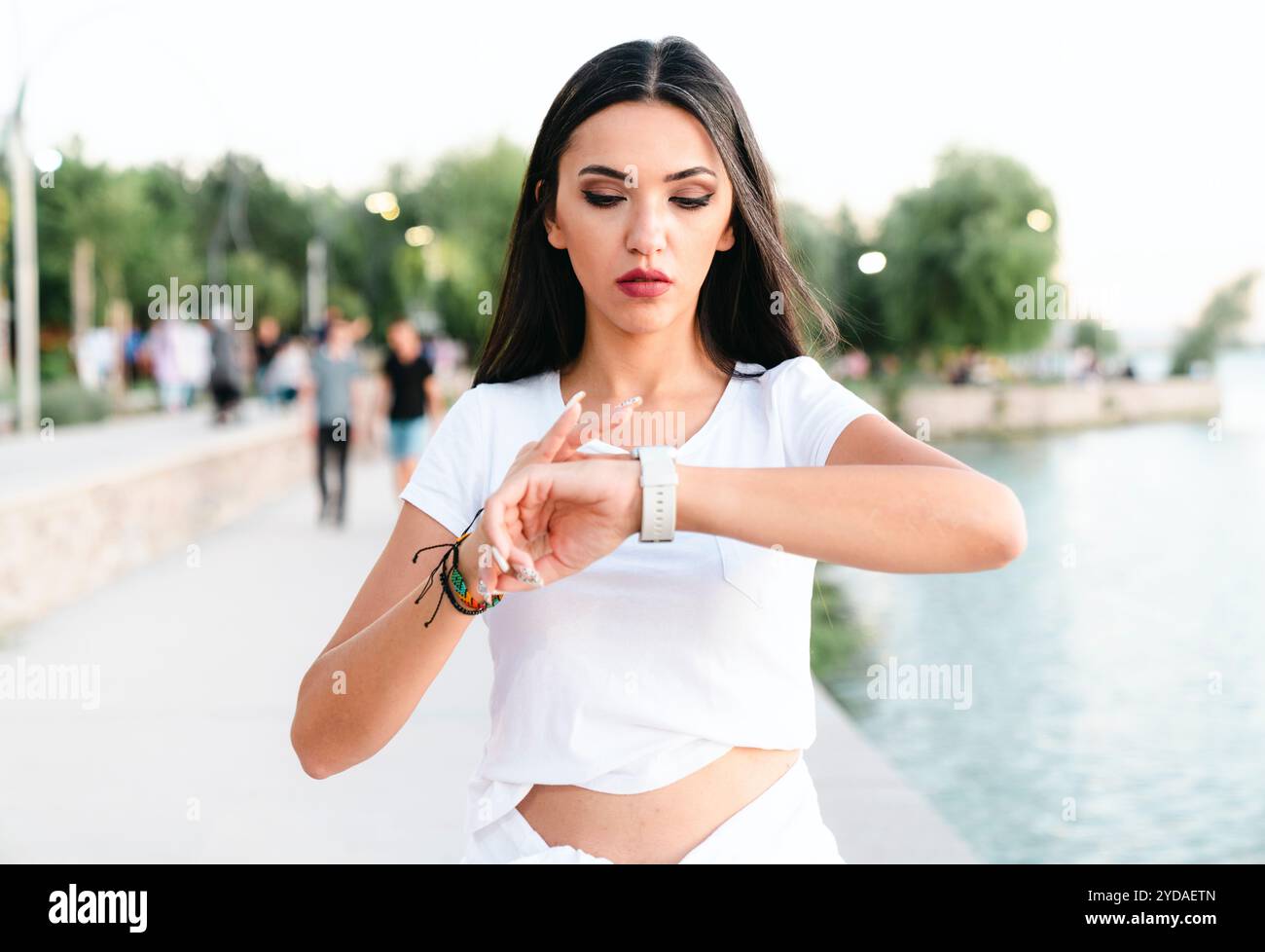 Frau überprüft ihre körperliche Aktivität auf Smartwatch. Junge Sportlerin, die während des Trainings auf Aktivitätstracker blickt. Stockfoto