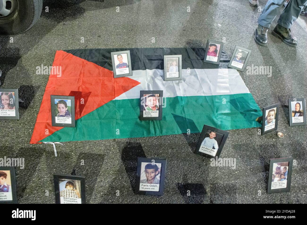Rom, Italien. Oktober 2024. Fotos von Kindern mit Namen und Alter, die während der Demonstration auf dem Boden auf der palästinensischen Flagge platziert wurden, als Reaktion auf den internationalen Aufruf #StopBotschaften am "Freitag der Wut" für Gaza, gegen den anhaltenden Völkermord im nördlichen Gazastreifen zu protestieren und die Waffenlieferungen an Israel zu stoppen, organisiert von der palästinensischen Studentenbewegung in der Nähe der US-Botschaft in Rom. Auf der ganzen Welt haben zahlreiche Proteste stattgefunden, als Reaktion auf den Aufruf der Hamas-Bewegung, die die˜arabischen und islamischen Massen und die freien Menschen der Welt einlud, zu handeln Stockfoto
