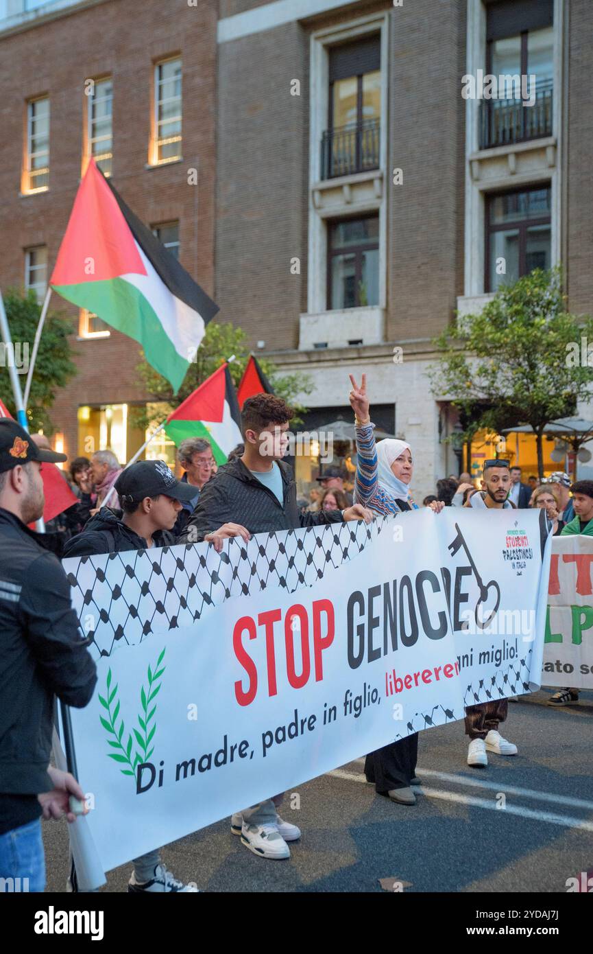 Rom, Italien. Oktober 2024. Die Demonstranten schwenken während der Demonstration palästinensische Flaggen hinter das Banner mit dem Slogan "stoppt den Völkermord" als Reaktion auf den internationalen Aufruf #StopBotschaften am "Freitag der Wut" für Gaza, gegen den anhaltenden Völkermord im Norden Gazas zu protestieren und die Waffenlieferungen an Israel zu stoppen, der von der palästinensischen Studentenbewegung in der Nähe der US-Botschaft in Rom organisiert wird. Auf der ganzen Welt haben zahlreiche Proteste stattgefunden, als Reaktion auf den Aufruf der Hamas-Bewegung, die die arabischen und islamischen Massen und die freien Menschen der Welt eingeladen hat, nicht˜ Stockfoto