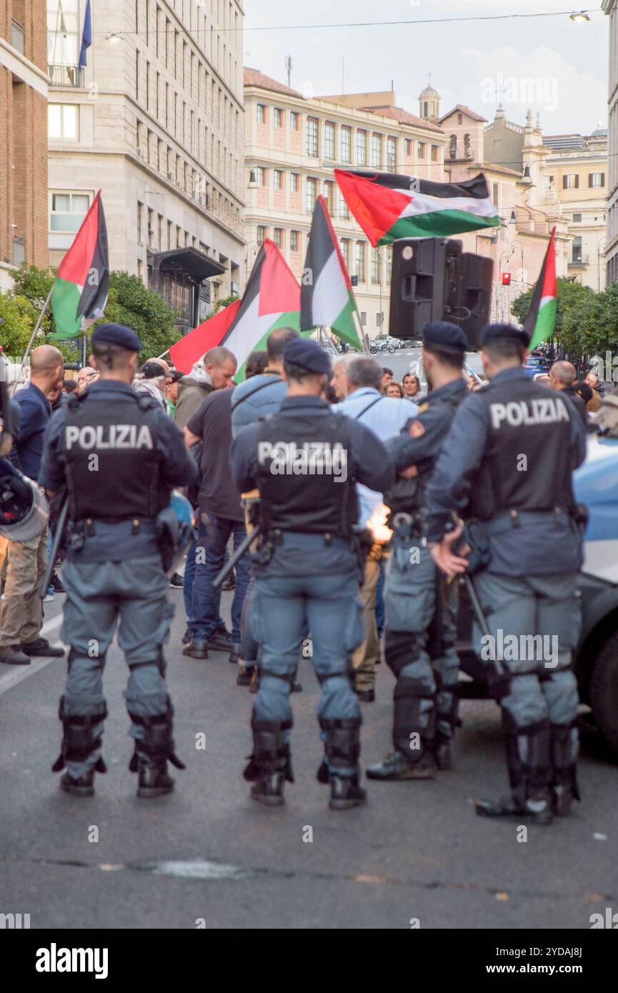 Rom, Italien. Oktober 2024. Polizeibeamte überwachen Demonstranten, die während der Demonstration palästinensische Flaggen schwenken, als Reaktion auf den internationalen Aufruf #StopBotschaften am "Freitag der Wut" für Gaza, gegen den anhaltenden Völkermord im nördlichen Gazastreifen zu protestieren und eine Einstellung der Waffenlieferungen an Israel zu fordern, die von der palästinensischen Studentenbewegung in der Nähe der US-Botschaft in Rom organisiert wird. Auf der ganzen Welt haben zahlreiche Proteste stattgefunden, um auf den Aufruf der Hamas-Bewegung zu reagieren, die "˜die arabischen und islamischen Massen und die freien Menschen der Welt" eingeladen hat, sich aktiv zu beteiligen Stockfoto