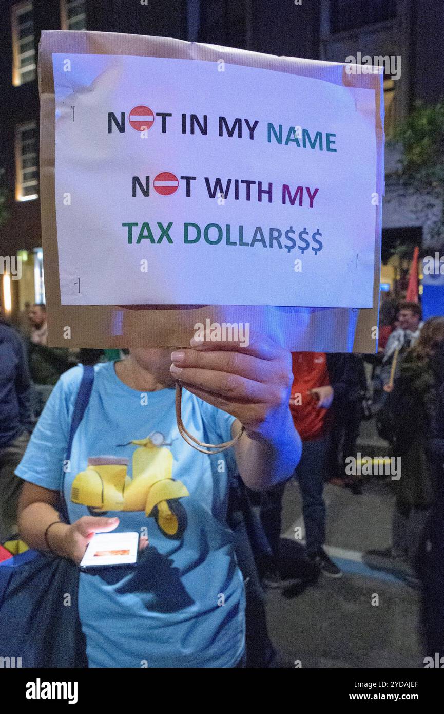 Rom, Italien. Oktober 2024. Ein Demonstrant hält während der Demonstration ein Schild mit dem Slogan "nicht in meinem Namen, nicht in meinen Steuergeldern" hoch, als Reaktion auf den internationalen Aufruf #StopBotschaften am "Freitag der Wut" für Gaza, gegen den anhaltenden Völkermord im Norden Gazas zu protestieren und die Waffenlieferungen an Israel zu stoppen, organisiert von der palästinensischen Studentenbewegung in der Nähe der US-Botschaft in Rom. Auf der ganzen Welt haben zahlreiche Proteste stattgefunden, als Reaktion auf den Aufruf der Hamas-Bewegung, die die˜arabischen und islamischen Massen und die freien Menschen der Welt einlud, zu handeln Stockfoto