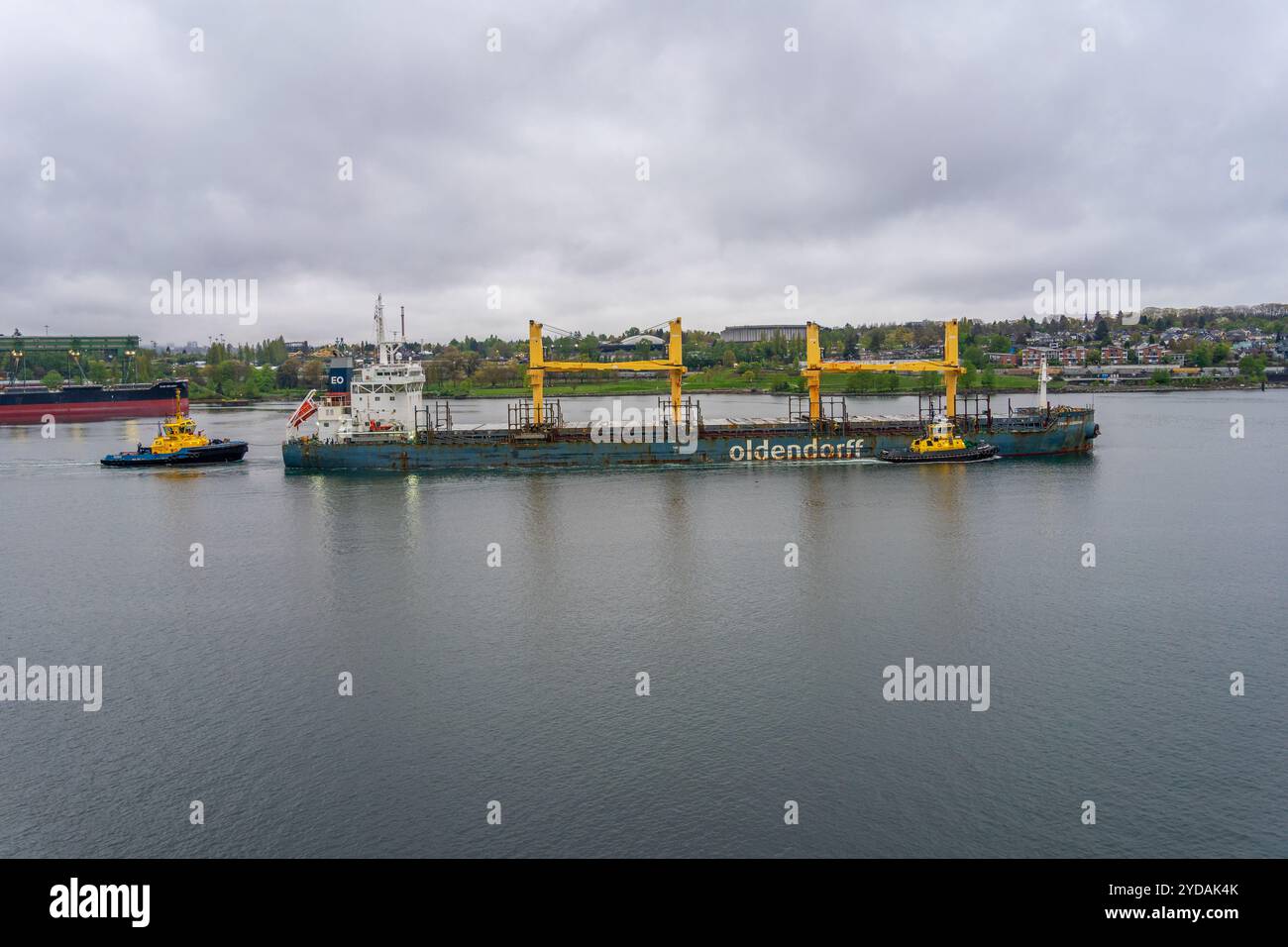 Vancouver, BC, Kanada - 26. April 2024: Ein Schlepper, der ein leeres Frachtschiff in den Gewässern von Vancouver, British Columbia, führt. Stockfoto
