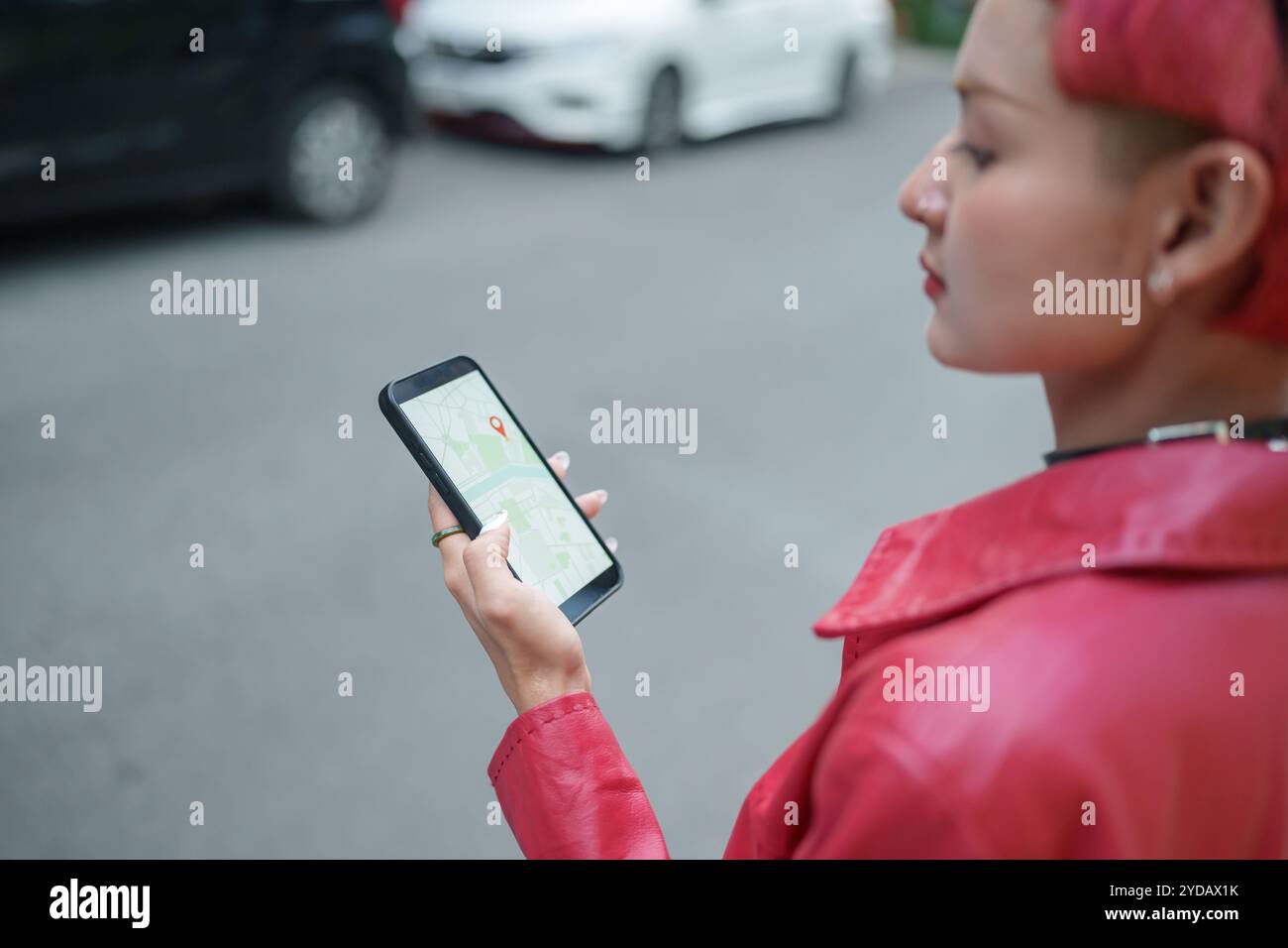 Traveler Gen z Mädchen Ledermode mit Punk asiatische Frau touristÂ in der Stadt Straße Suche Standort in Karte Anwendung online s Stockfoto