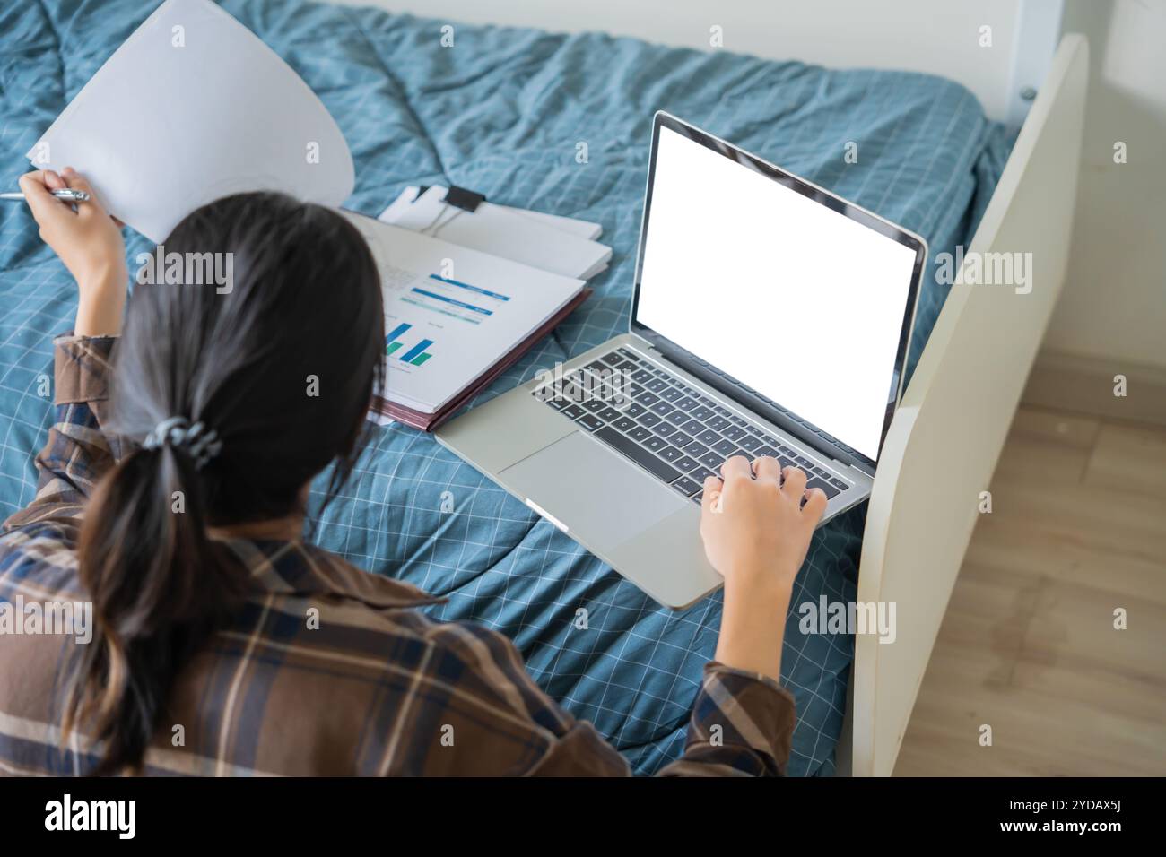 asiatische Studentin sitzt auf Bett im Studentenwohnheim College studentÂ Arbeit oder Hausaufgaben auf Laptop im Studentenwohnheim. Stockfoto