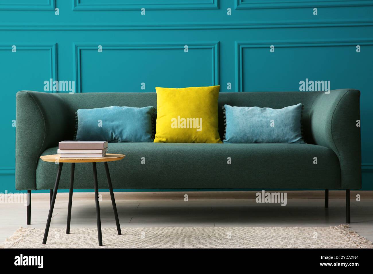 Komfortables Sofa und Tisch in der Nähe der blauen Wand im Zimmer Stockfoto