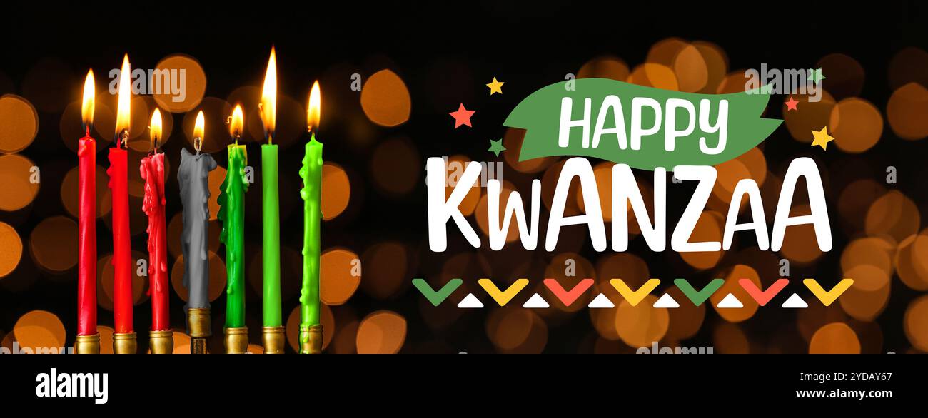 Brennende Kerzen und Text HAPPY KWANZAA auf dunklem Hintergrund Stockfoto