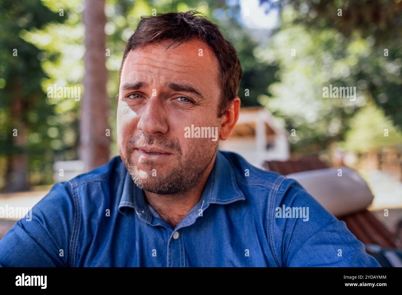 Ein Nahporträt im Profil eines attraktiven Mannes in einem Jeanshemd. Stockfoto