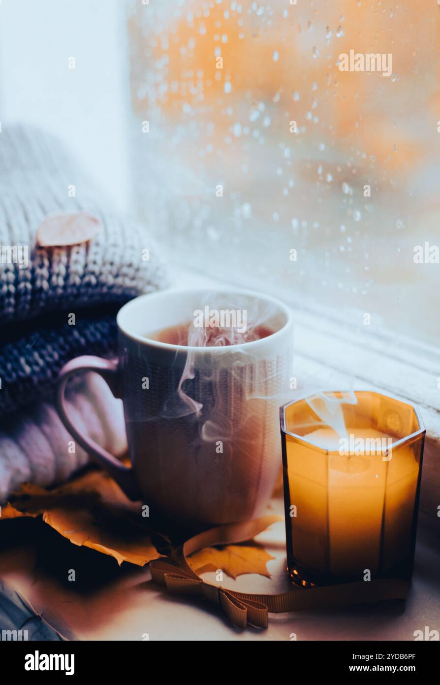 Eine brennende Kerze am Fenster ist Herbst. Der Komfort von zu Hause. Herbstlicher Komfort. Herbststimmung. Die Chondra. Gemütliche Atmosphäre Stockfoto Eine brennende Kerze am Fenster ist Herbst. Der Komfort von zu Hause. Herbstlicher Komfort. Herbststimmung. Die Chondra. Gemütliche Atmosphäre Stockfoto