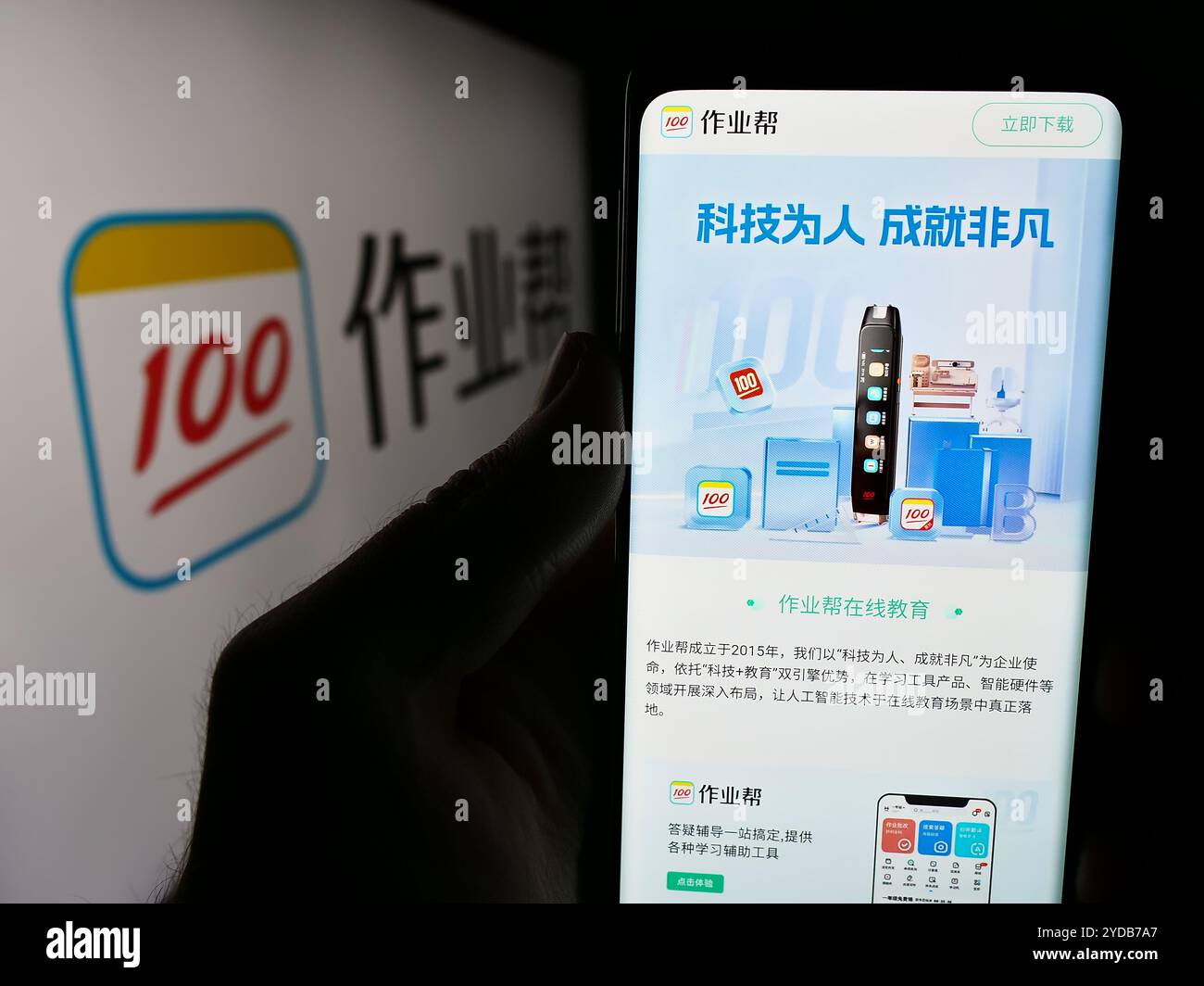 In dieser Fotoabbildung hält eine Person ein Handy mit der Webseite des chinesischen Online-Bildungsplattform Zuoyebang vor dem Logo. Stockfoto