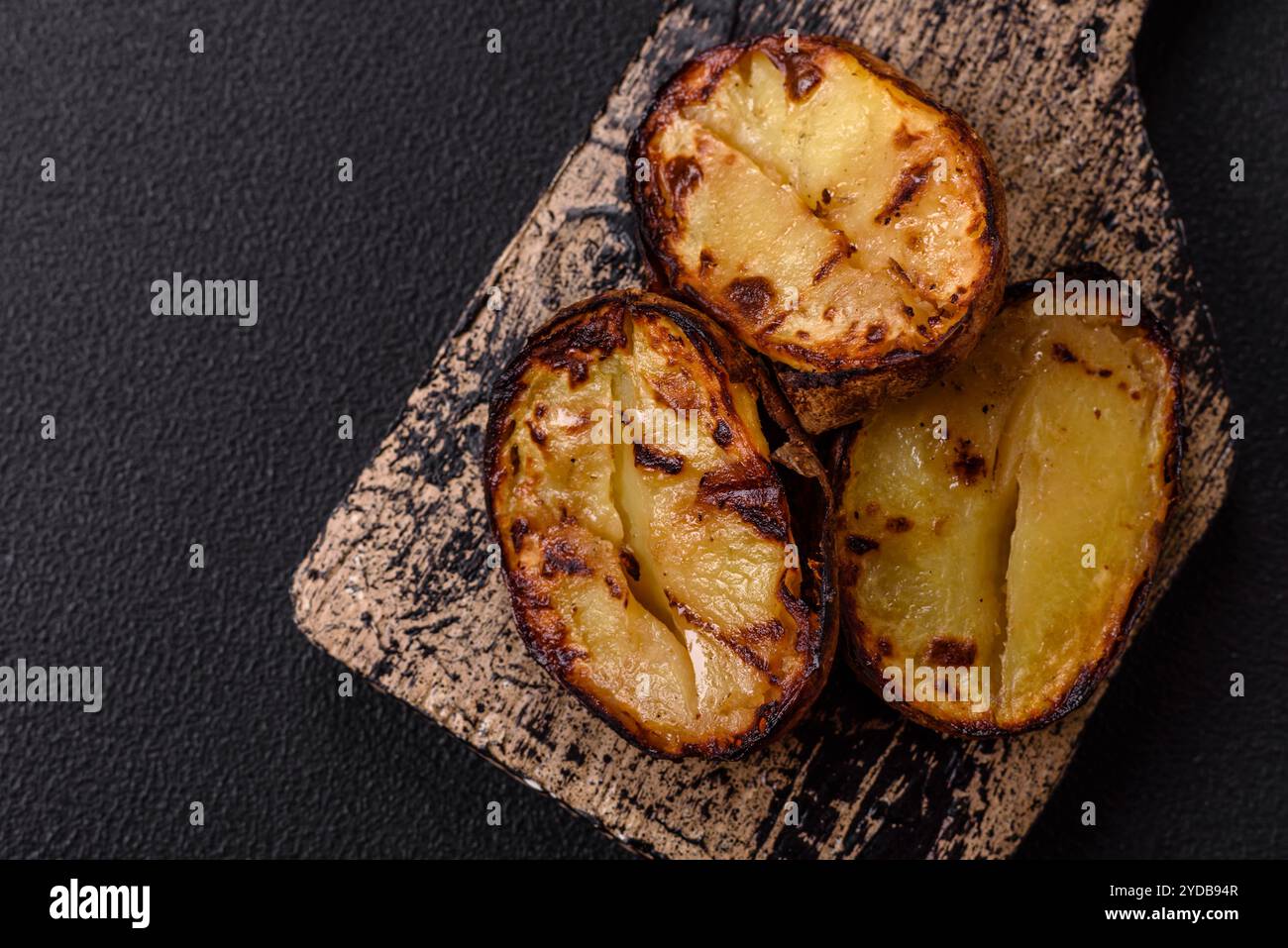 Köstliche Kartoffelhälften in Schalen, die auf dem Grill gebacken werden Stockfoto