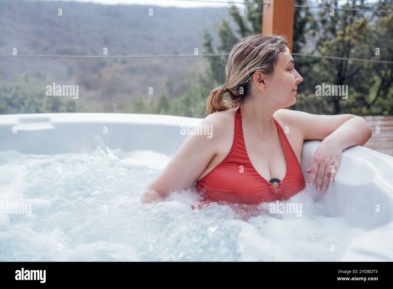 Nahaufnahme Porträt einer jungen Frau im Badeanzug, die sich in einem Whirlpool entspannt. Eine attraktive Blondine genießt es, sich im wirbelnden Wasser auszuruhen Stockfoto