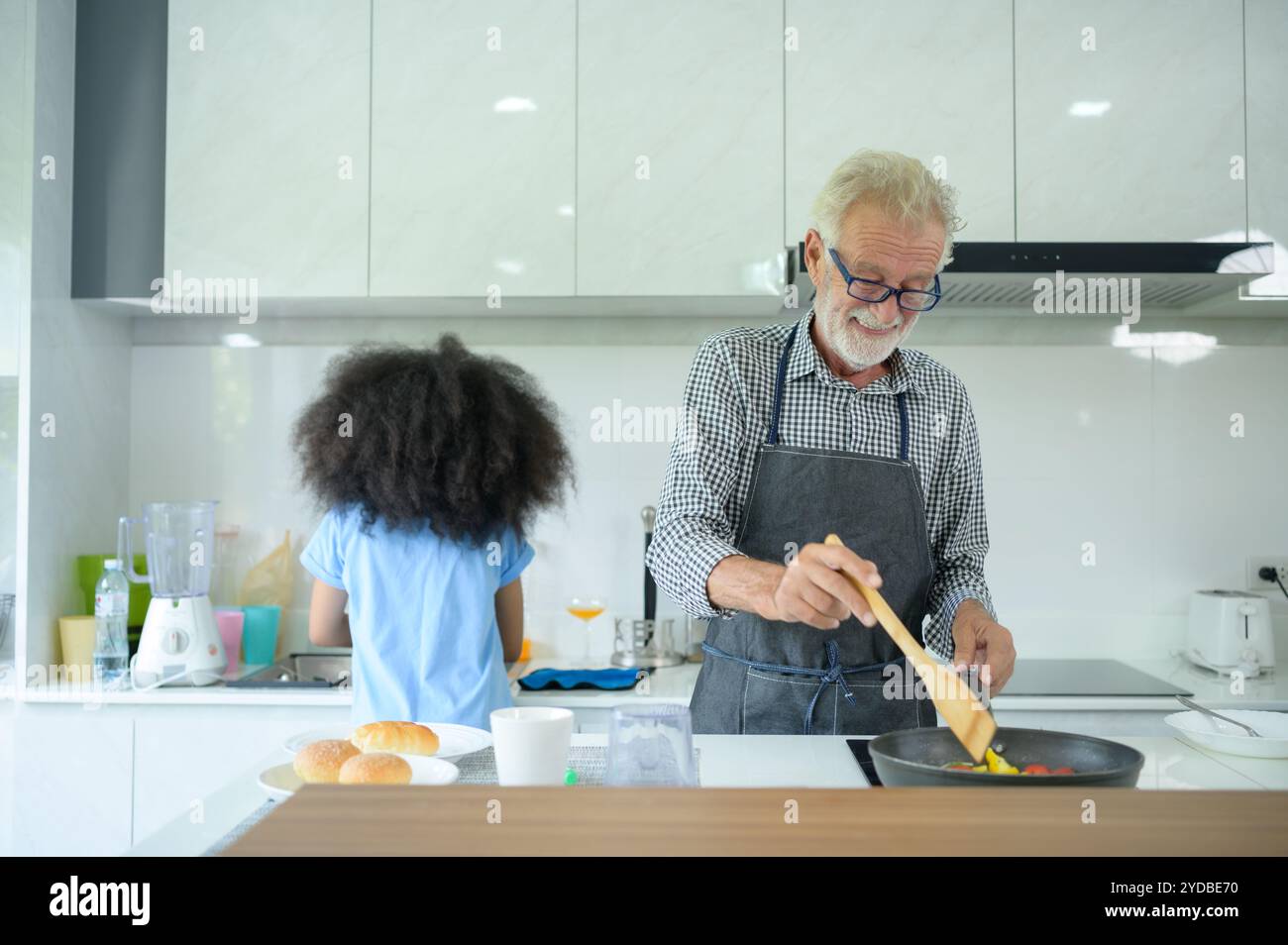 Familienurlaub mit Großvater und Enkelkindern. Zusammen zu kochen für den Großvater der Familie, lehrt Coo Stockfoto