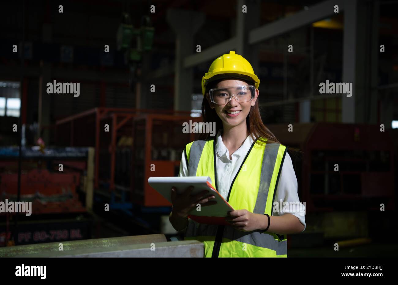 Die weibliche Führungskraft arbeitet im Auditbereich. Sie arbeitet daran, die Qualität der Arbeit in schweren Industrieanlagen zu überprüfen Stockfoto