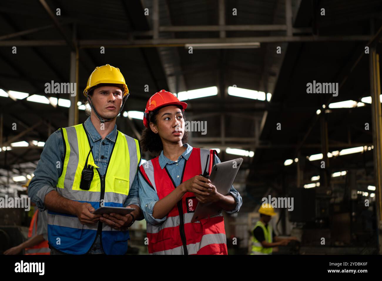 Der ausländische Chefingenieur kam, um die alte Maschinenfabrik zu inspizieren. Es gibt eine afrikanische Mechanikerin, die Details erklärt Stockfoto