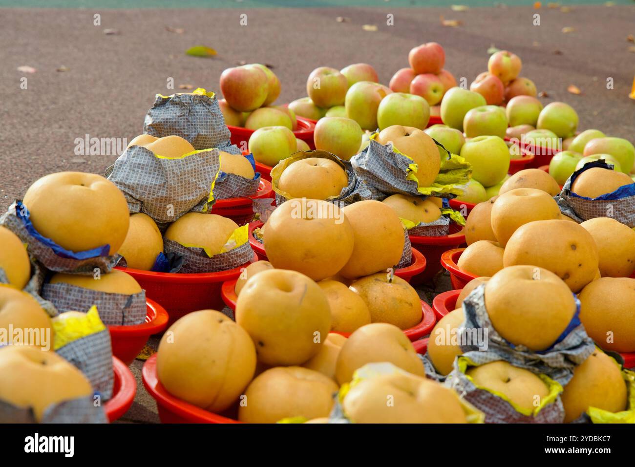 Ulsan, Südkorea - 5. Oktober 2024: Frische Äpfel und koreanische Birnen werden in roten Körben zum Verkauf am Straßenrand in der Nähe des Taehwa River Nat ausgestellt Stockfoto