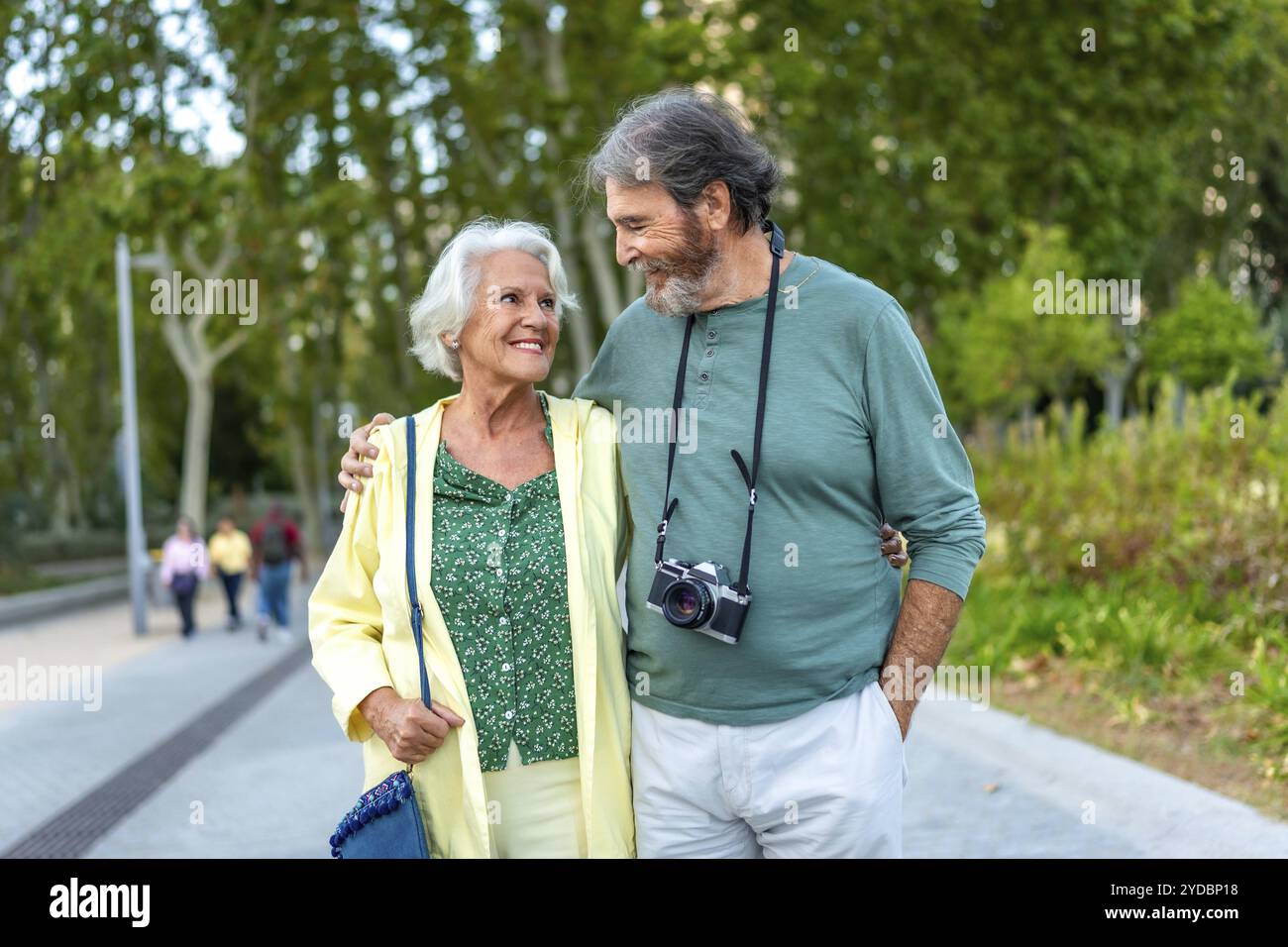 Frontalansicht eines älteren Menschen, der umarmt geht und einen Stadtpark besucht Stockfoto