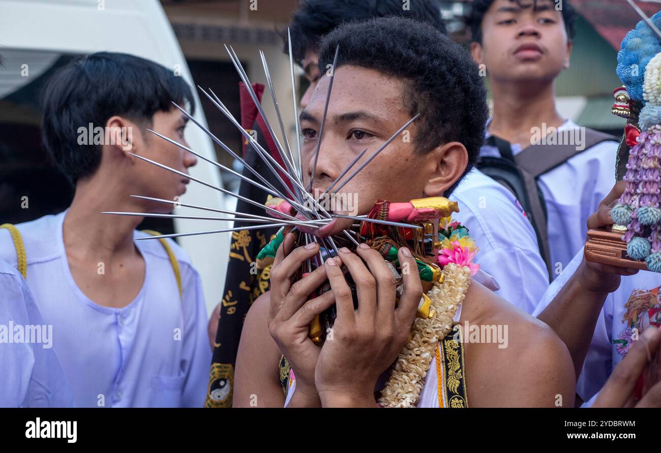 Ein Gläubiger läuft in einer Prozession, nachdem er während des jährlichen Vegetarian Festival in Phuket Town am Baan Tha Rua Schrein durchbohrt wurde. Das Festival brachte 15 Milliarden Thai Baht in die lokale Wirtschaft mit über 400.000 Besuchern ein. Stockfoto