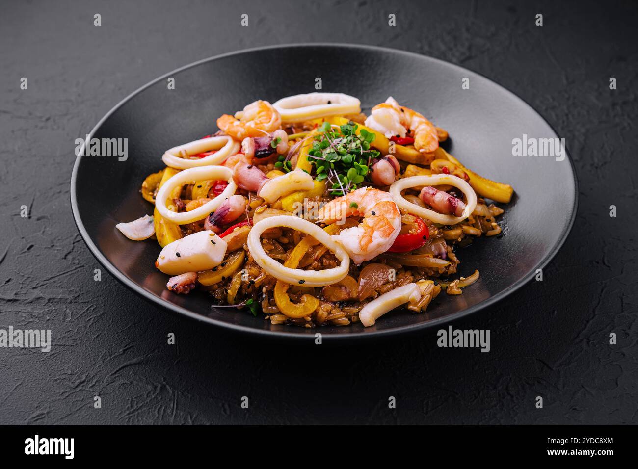 Thailändischer, scharfer Salat mit Meeresfrüchten auf schwarzem Teller Stockfoto