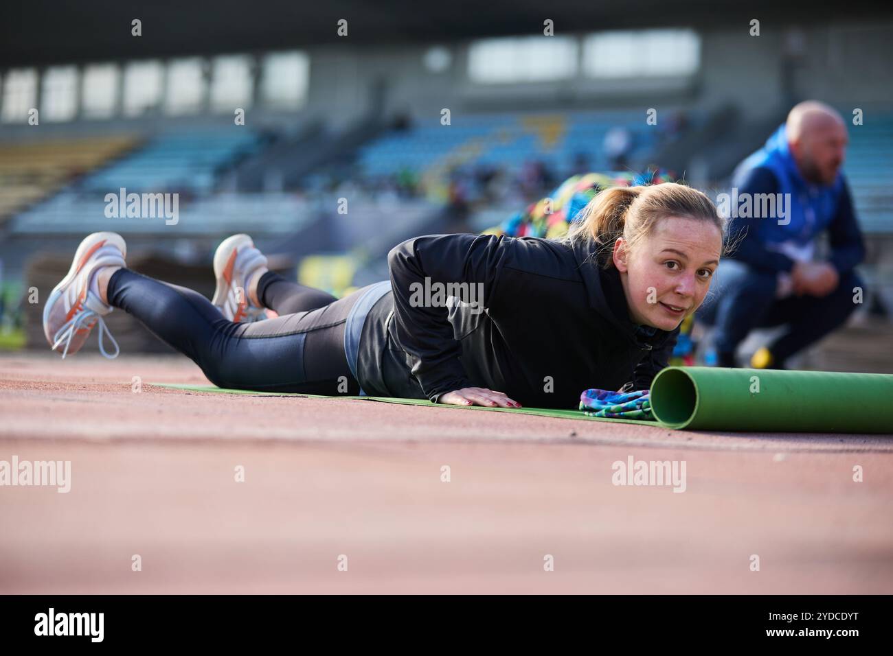 Junge Frau, die Burpees während des Gruppentrainings im Freien machen will. Kiew - 19. Oktober 2024 Stockfoto