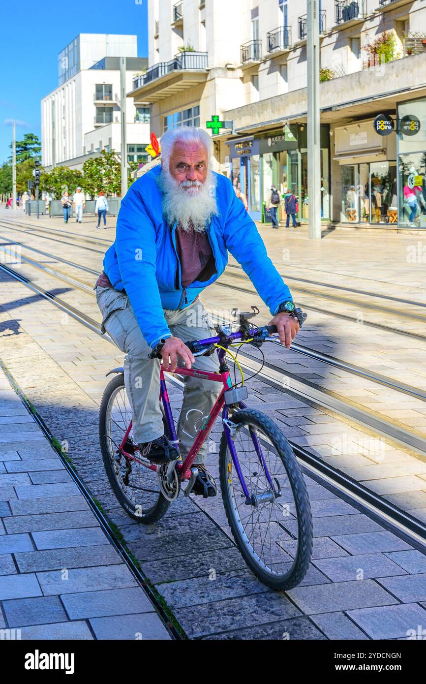 Indischer Mann mit langem weißem Bart auf dem Fahrrad neben der Straßenbahn - Tours, Indre-et-Loire (37), Frankreich. Stockfoto