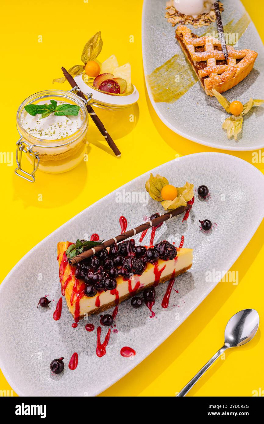 Köstliches Stück Käsekuchen mit schwarzer Johannisbeere und Erdbeersauce Stockfoto