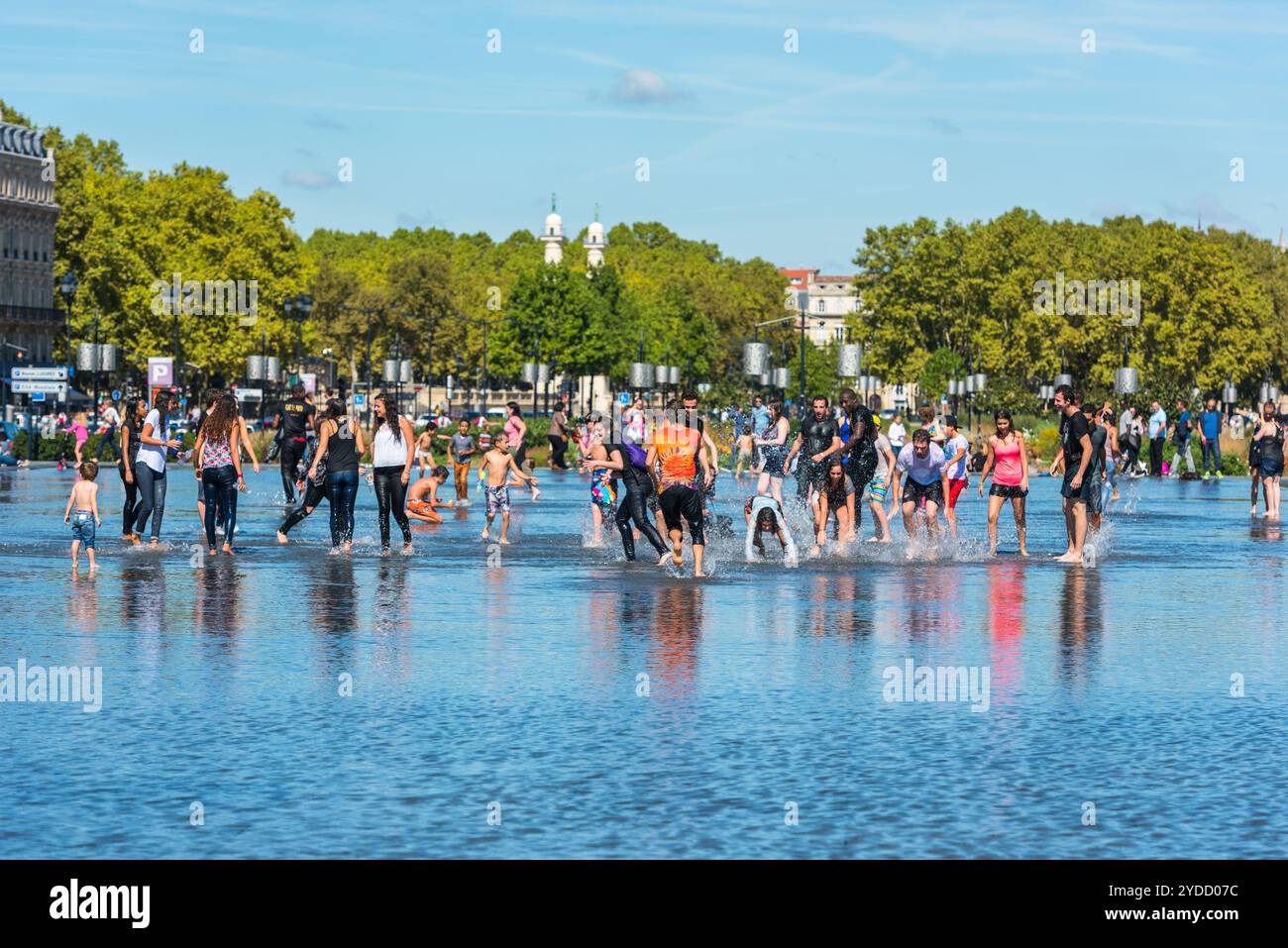 Leute, die sich in einem Spiegelbrunnen in Bordeaux, Frankreich, amüsieren Stockfoto