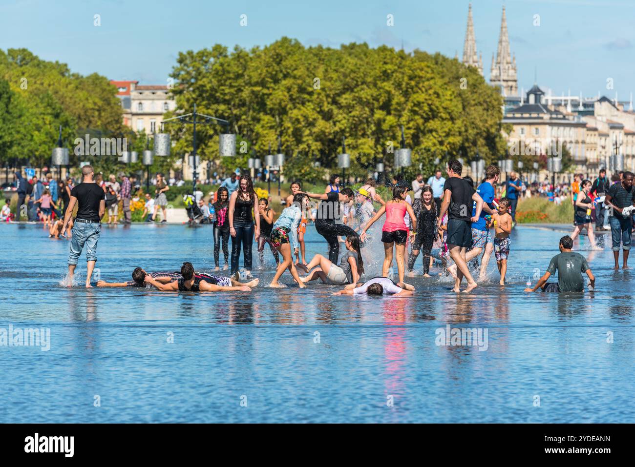 Leute, die sich in einem Spiegelbrunnen in Bordeaux, Frankreich, amüsieren Stockfoto