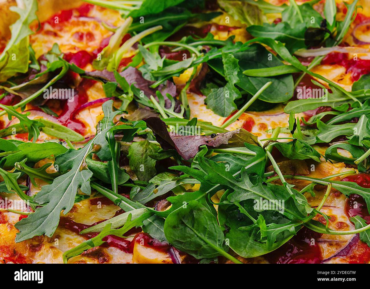 Pizza mit Rucola-Hintergrund Stockfoto