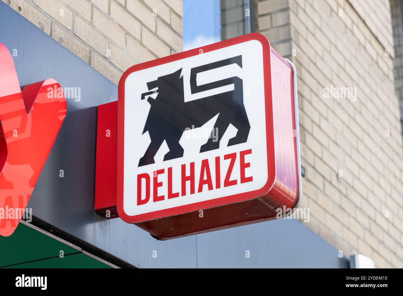 Delhaize Shop Logoschild über dem Eingang des Geschäfts. Ahold Delhaize ist einer der weltweit größten Lebensmitteleinzelhandelsgeschäfte. Antwerpen, Belgien. 15. April 2023. Stockfoto