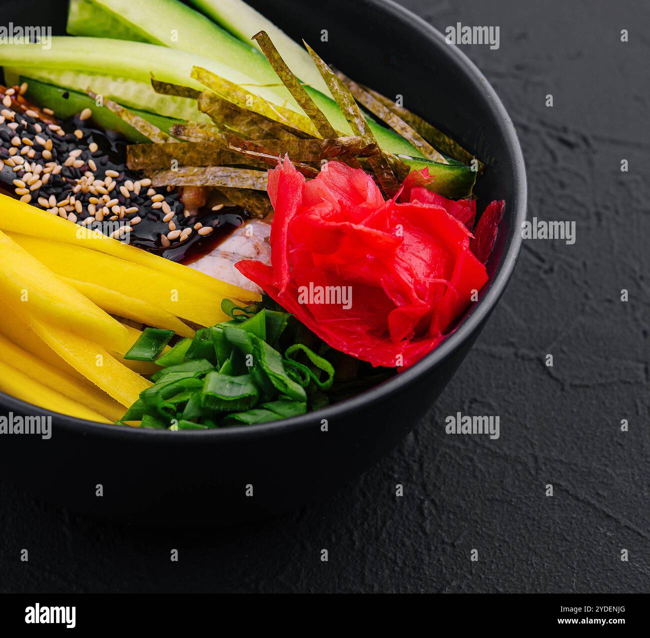 Eine Schüssel mit Mango, Gurke und Aal in Unagi-Sauce geben Stockfoto