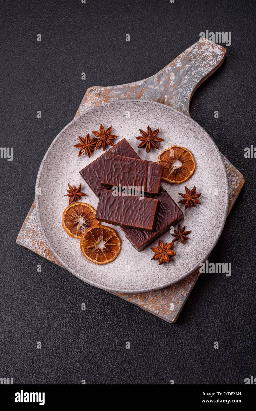 Rechteckige Schokoladenbonbons mit Mousse und Waffeln auf dunklem Betonhintergrund Stockfoto