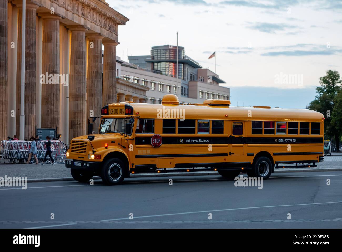 BERLIN, DEUTSCHLAND - 6. AUGUST 2016: Amerikanischer gelber Schulbus International 3800 von Mein-Eventbus.de Unternehmen in der Nähe des Brandenburger Tor in der Abenddämmerung Stockfoto