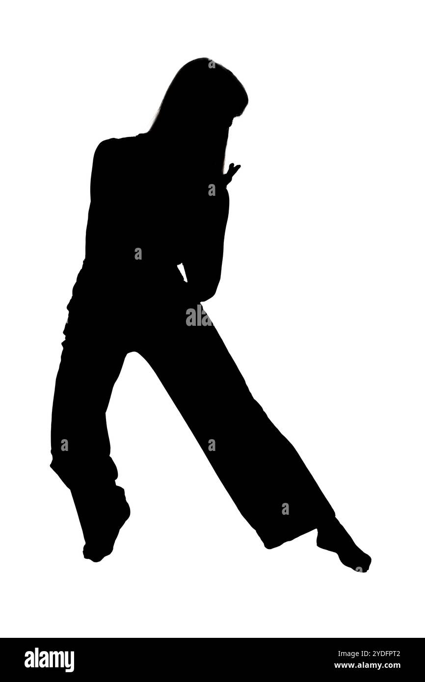 Eine markante Silhouette einer Person, die deutlich vor einem sauberen weißen Hintergrund steht und einen auffälligen visuellen Kontrast erzeugt, der die Aufmerksamkeit auf sich zieht Stockfoto