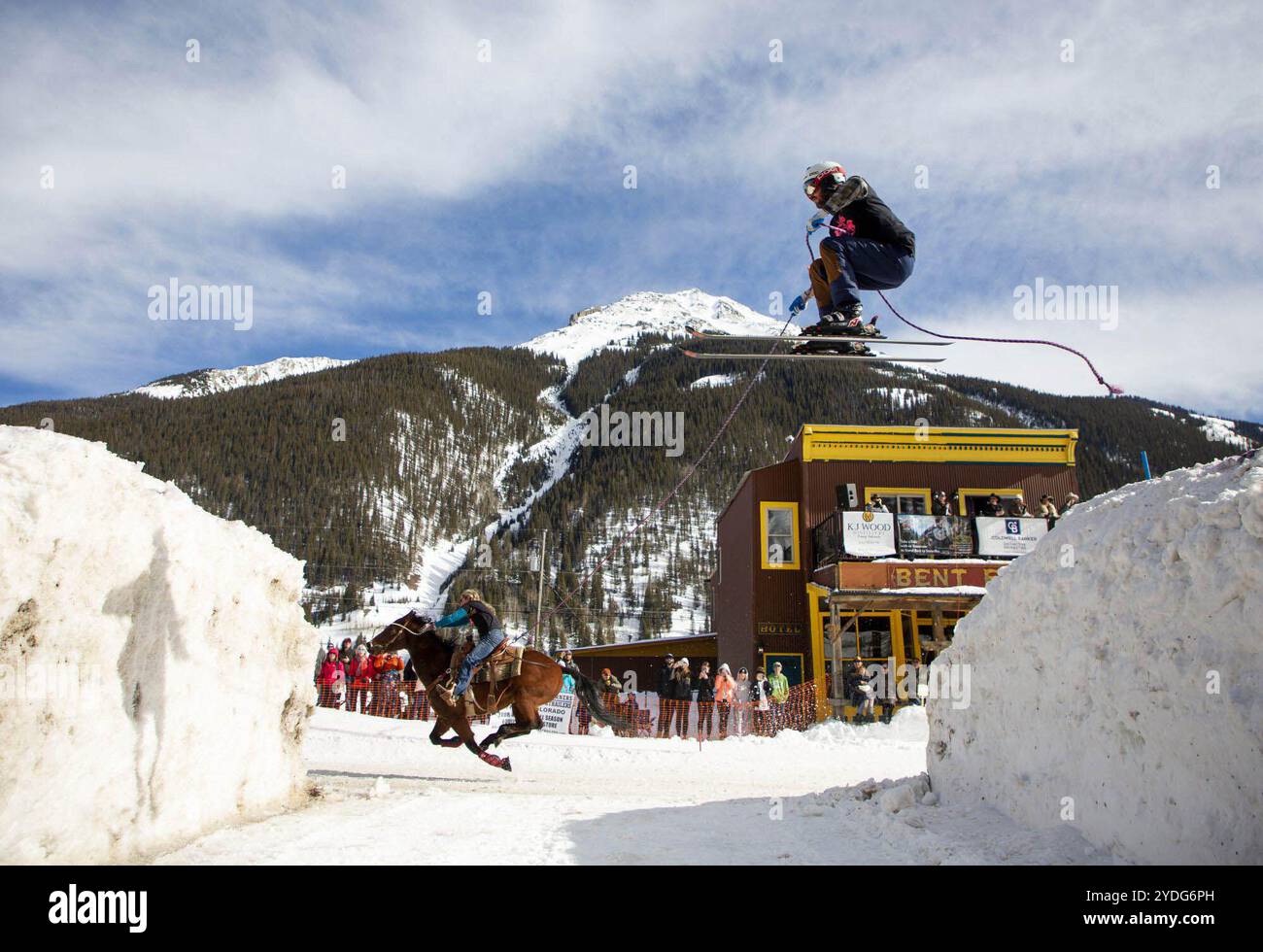 Denver, Colorado, USA. Oktober 2024. Der Skier Colin Cook trifft den Sprung mit Hilfe der Harley the Horse und der Reiterin Amanda Sanders während des Skisportrennen auf der Blair Street in Silverton am 20. Februar 2022. (Kreditbild: © Hugh Carey/Colorado Sun via ZUMA Press Wire) NUR REDAKTIONELLE VERWENDUNG! Nicht für kommerzielle ZWECKE! Stockfoto