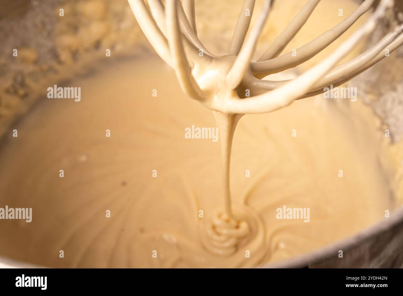 Der Teig wird in einem Planetenmischer verknetet. Der Pfannkuchen- oder Pie-Teig tropft vom Mixer. Hochwertige Fotos Stockfoto