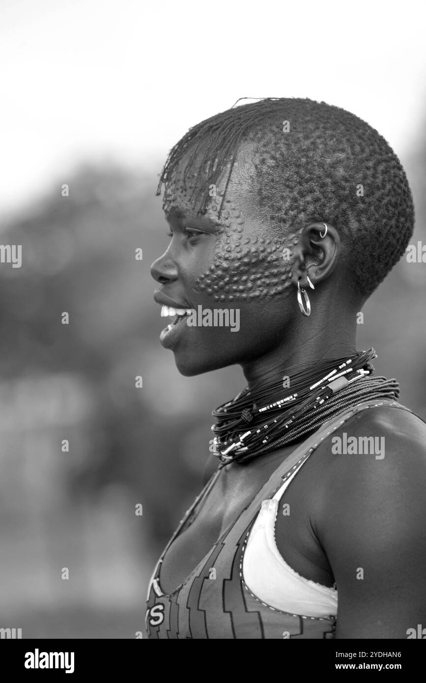 Ein lächelndes Karimojong-Mädchen mit Gesichtstätowierungen in Kotido, Karamoja Uganda. Unter den Karimojong-Stämmen symbolisieren die Gesichtstattoos Schönheit. Stockfoto