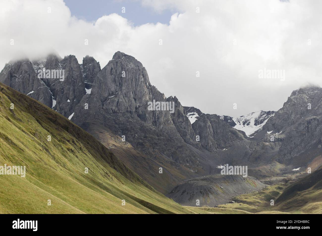 Ein atemberaubender Blick auf eine gewaltige Bergkette, wo steile, zerklüftete Gipfel die Landschaft dominieren. Die Klippen sind scharf und zerklüftet Stockfoto