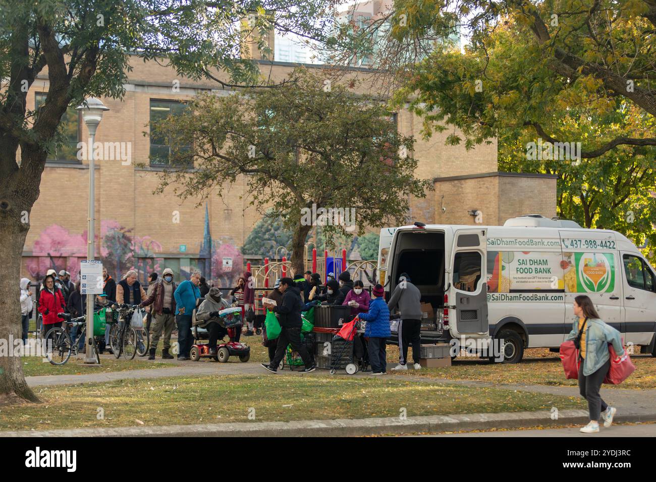 Die Leute stellen sich in einem Park in der Innenstadt von Toronto für Lebensmittel aus einer mobilen Lebensmittelbank an. Ernährungsunsicherheit ist in Kanadas größter Stadt zu einem Thema geworden Stockfoto